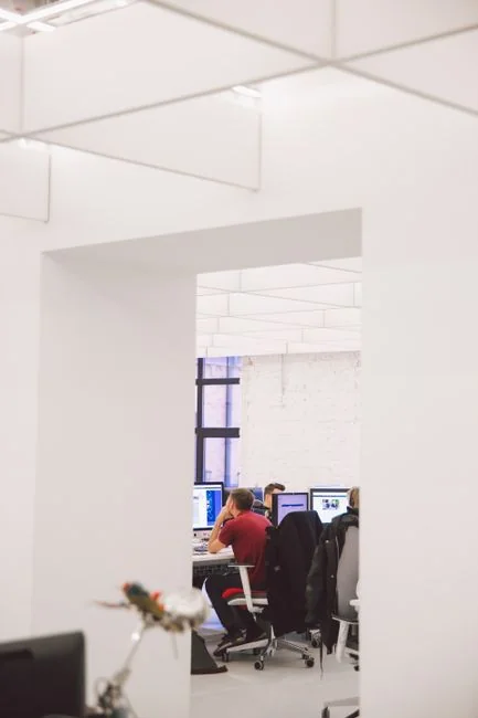 Un ordinateur portable posé sur un lit affichant un logiciel de conception web, aménageant un espace de travail chaleureux.